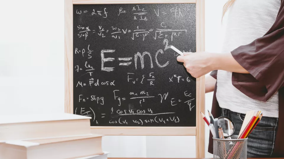 Image showing a person pointing at a blacboard with e=mc2