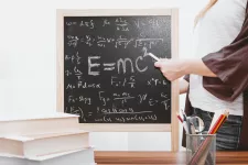 Image showing a person pointing at a blacboard with e=mc2