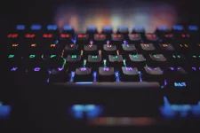 Photo showing a close-up of a black keyboard where the letters of the keys have the different colors of the rainbow.