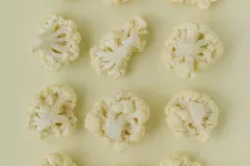 Photo of cauliflower heads in different shapes on a pale yellow background.