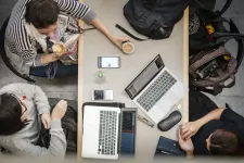 Photo showing three students around a table taken from above.