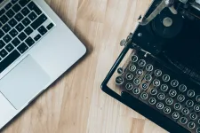 Close-up of a laptop and a typewriter side by side – symbolizing comparison of texts. Photography.