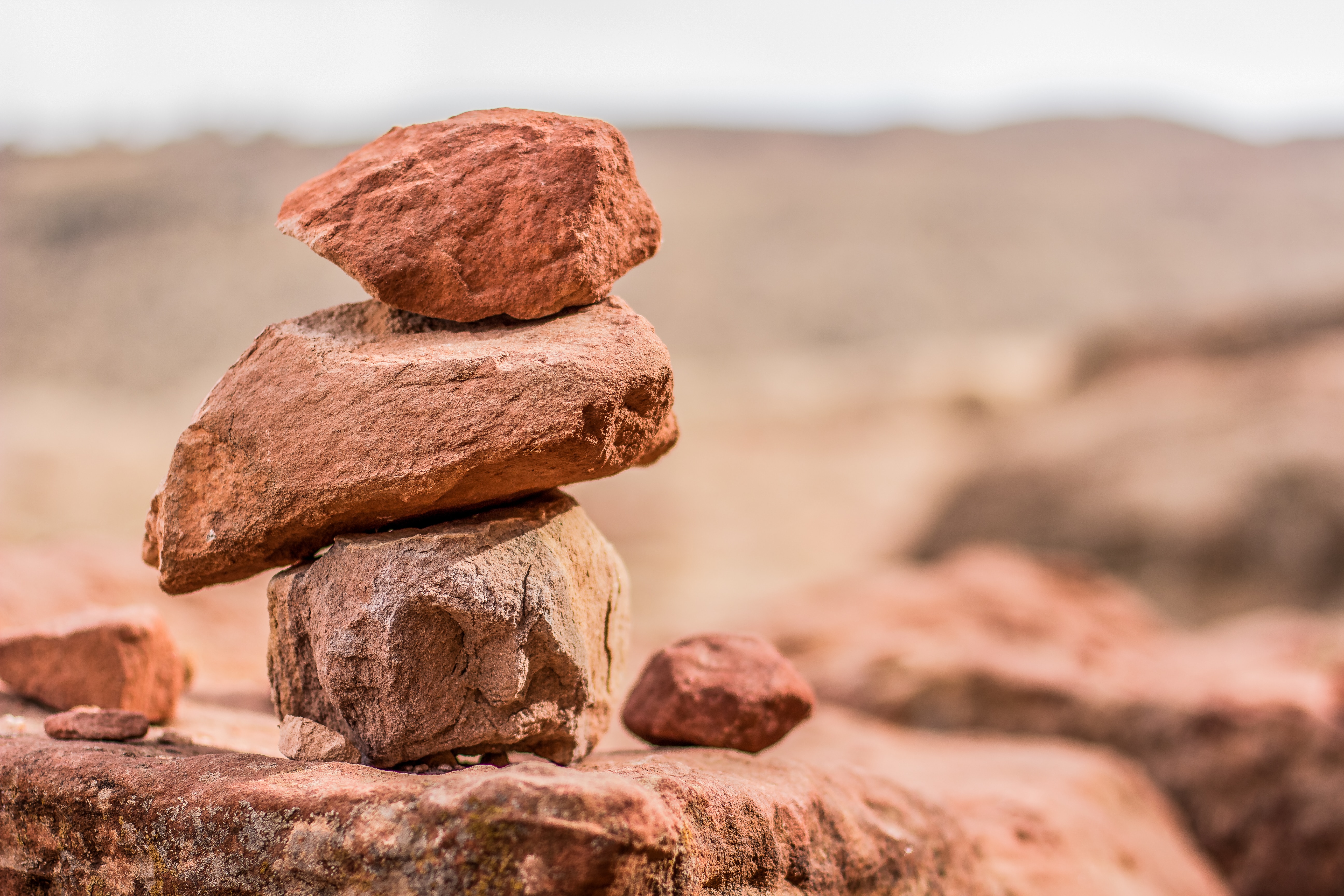 Foto som visar tre bruna stenblock staplade på varandra i ett klipplandskap.
