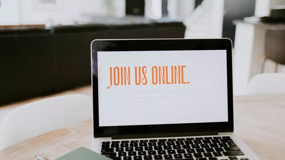 Bild på en laptop med texten "join us online".