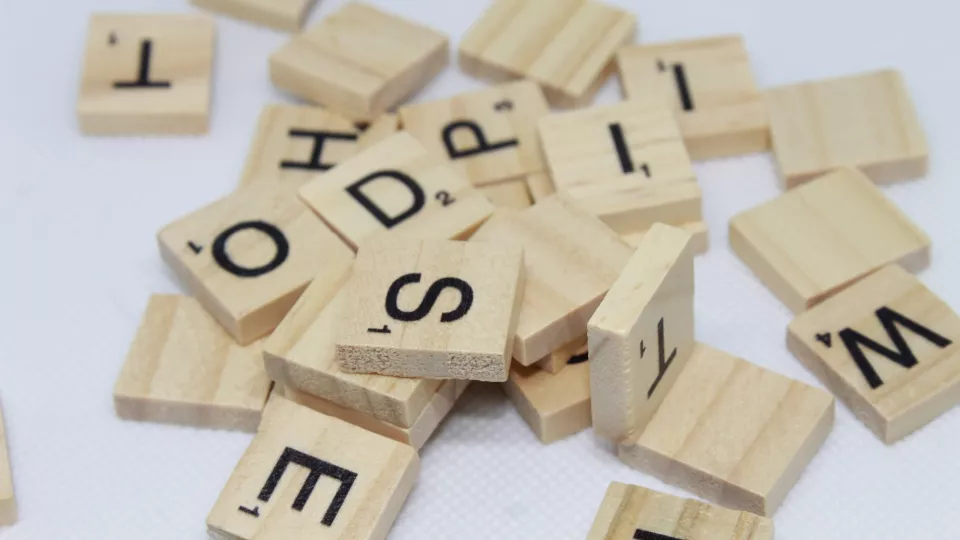 Foto som visar en rörig hög med bokstäver på träbrickor på ett bord.