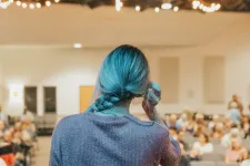 Foto som visar ryggen av en lärare som står framför en grupp sittande personer.